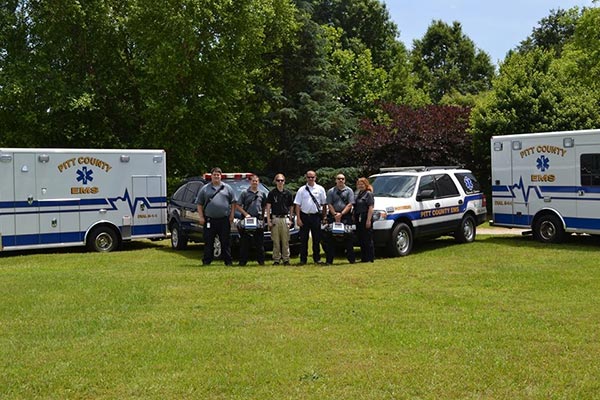 Students standing in front of Pitt County EMS ambulances and first response vehicles