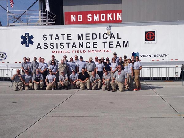 Students standing in front of a State Medical Assistance Team Mobile Field Hospital